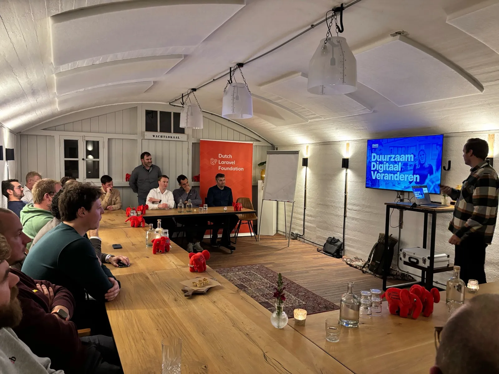 Kobalt-developers aan tafel bij een event van de Dutch Laravel Foundation, met de DLF-banner op de achtergrond