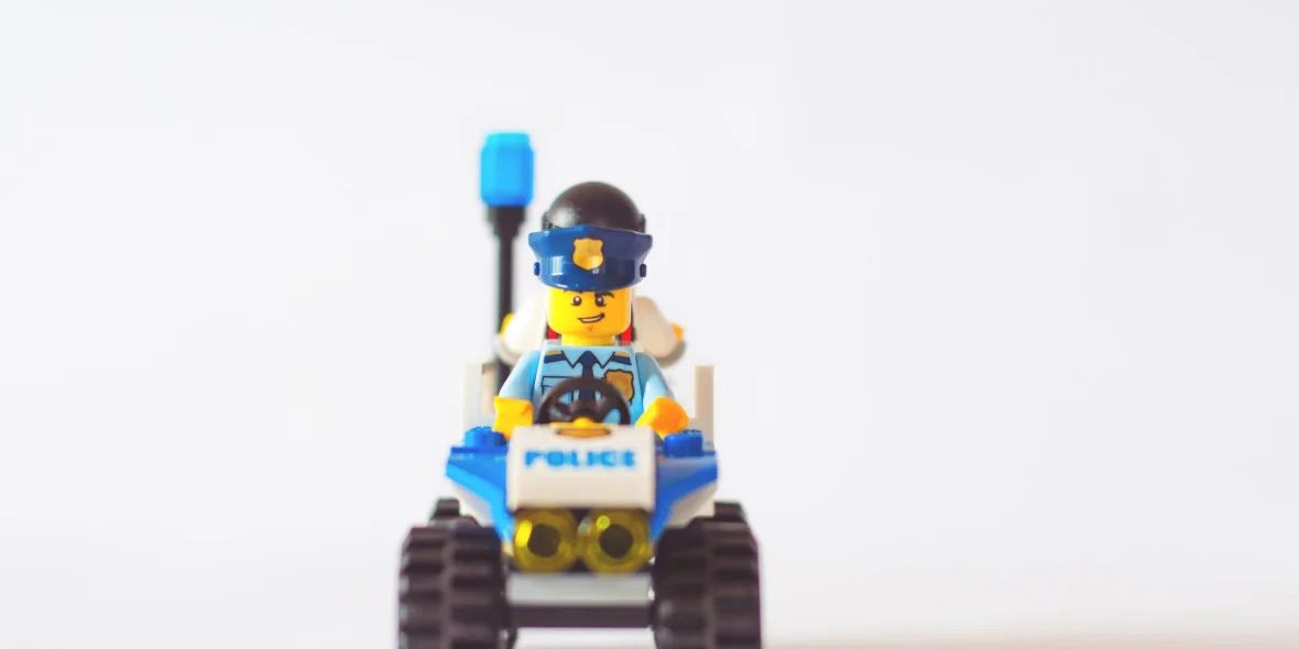 Lego politieauto met een politieagent voorin en een boef achterin