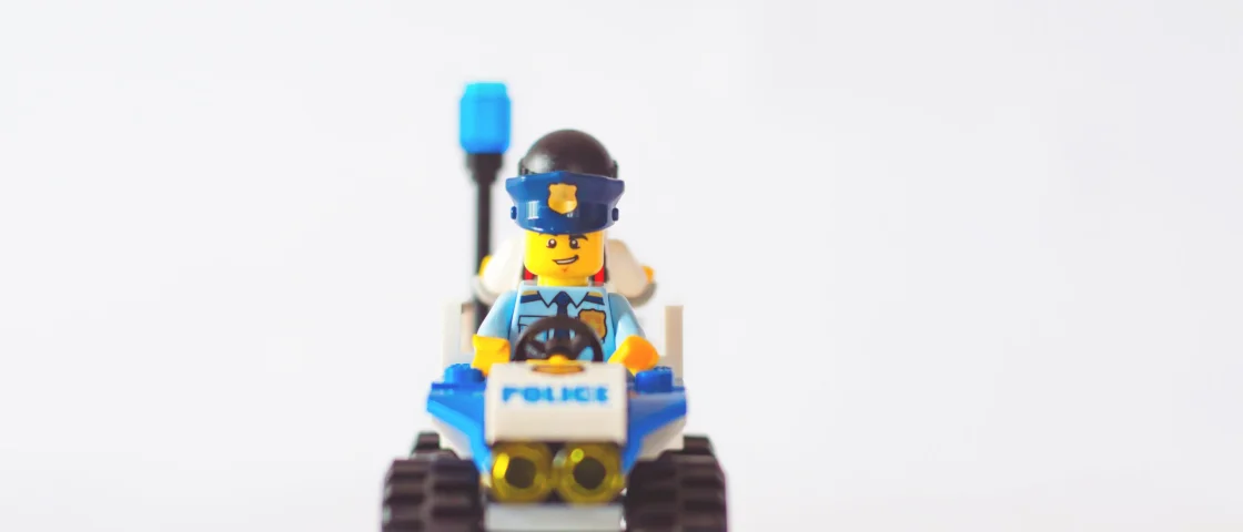 Lego politieauto met een politieagent voorin en een boef achterin