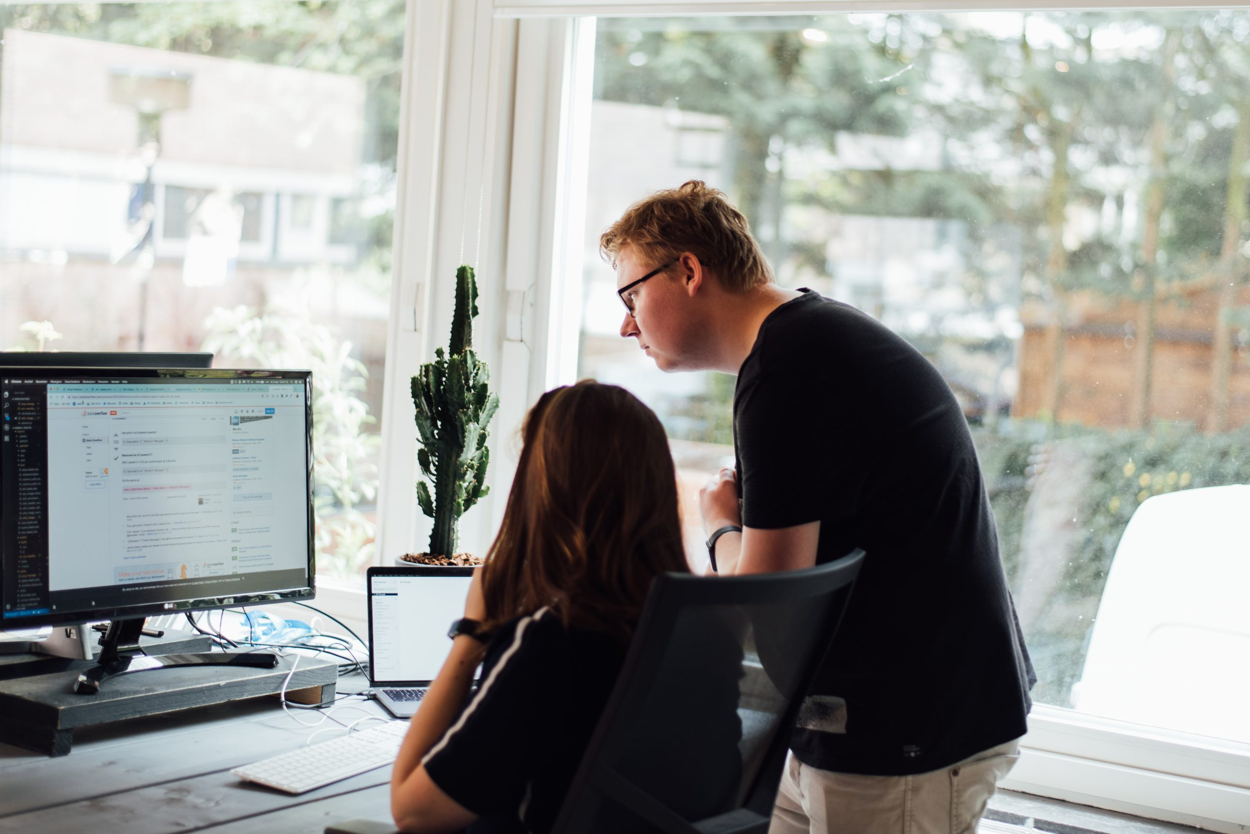 Medewerker kijkt met een andere medewerker op haar computerscherm mee