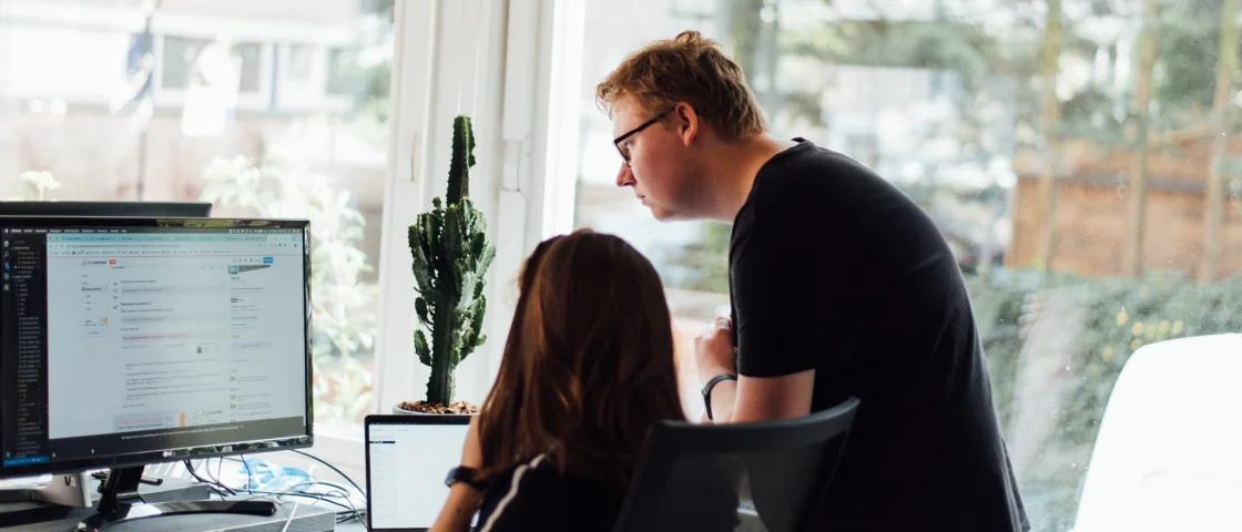 Medewerker kijkt met een andere medewerker op haar computerscherm mee