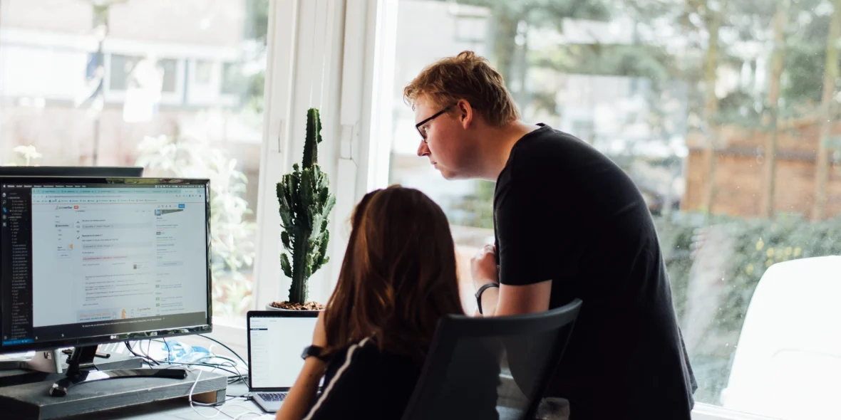 Medewerker kijkt met een andere medewerker op haar computerscherm mee