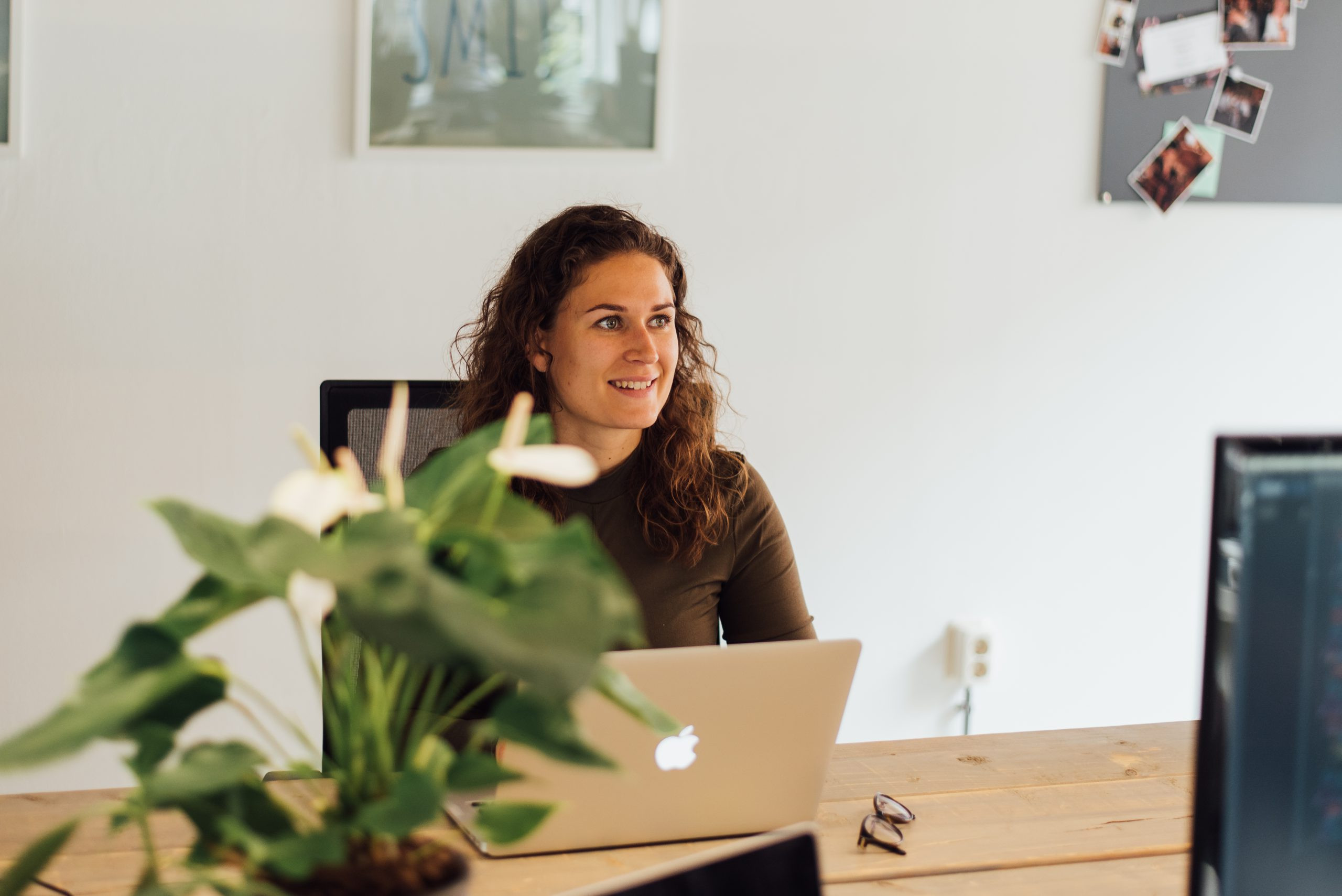 Medewerker zit aan haar bureau en is aan het werk op haar laptop