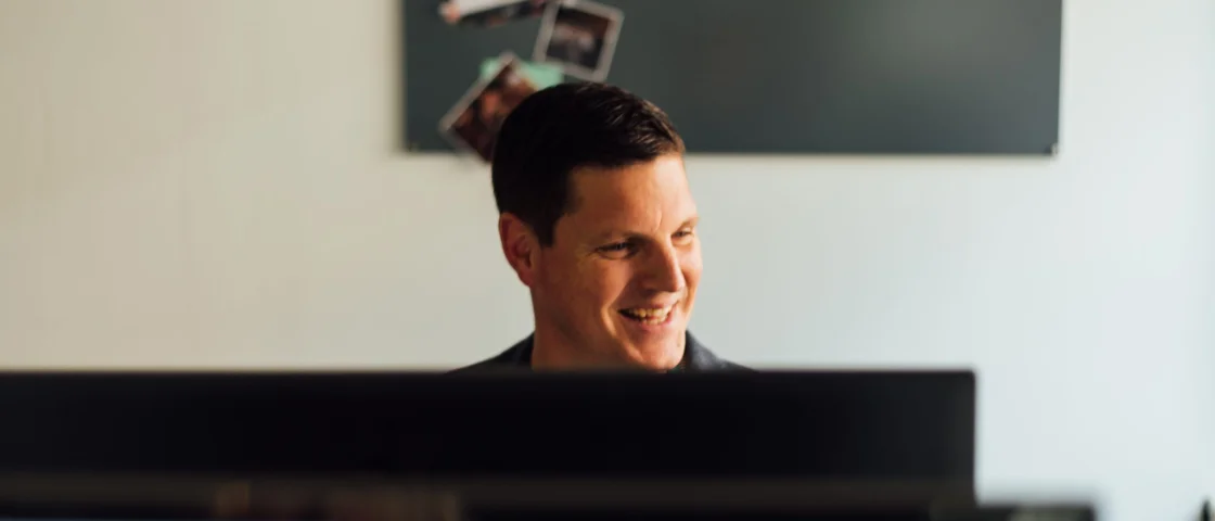 Arne lachend aan zijn computer