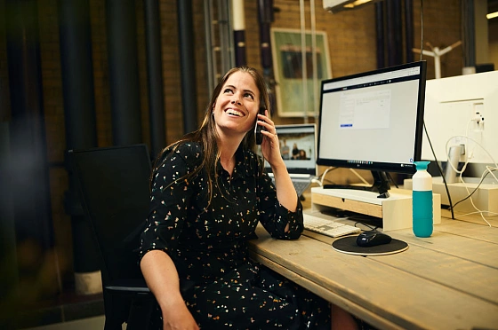 Brenda aan haar bureau aan de telefoon