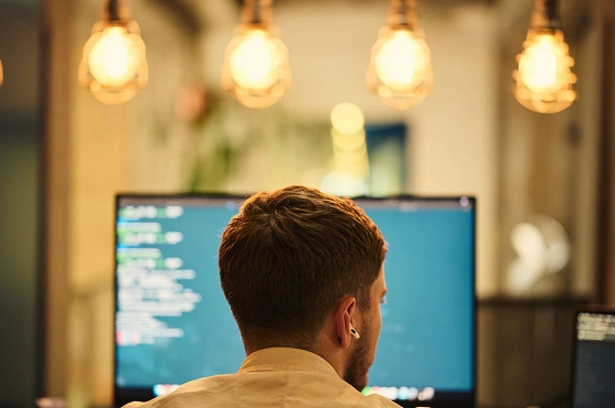 Huub van Kobalt zit met zijn rug naar de camera en is aan het werk op zijn computer