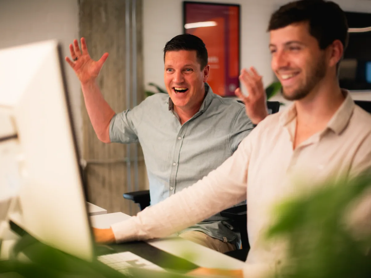 Twee Kobalt-developers lachen samen achter hun werkplek