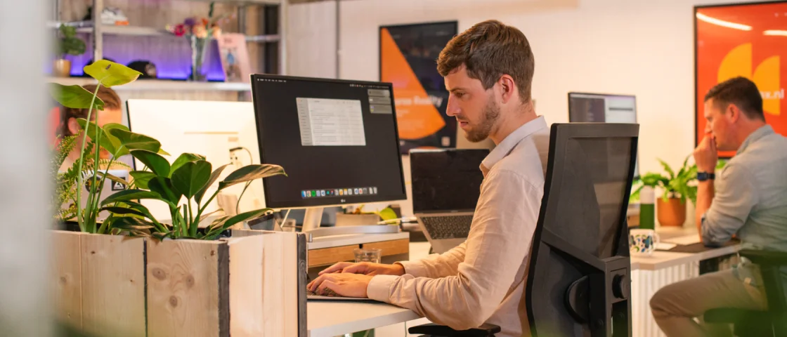 Huub die focus heeft op laptop en Arne op de achtergrond