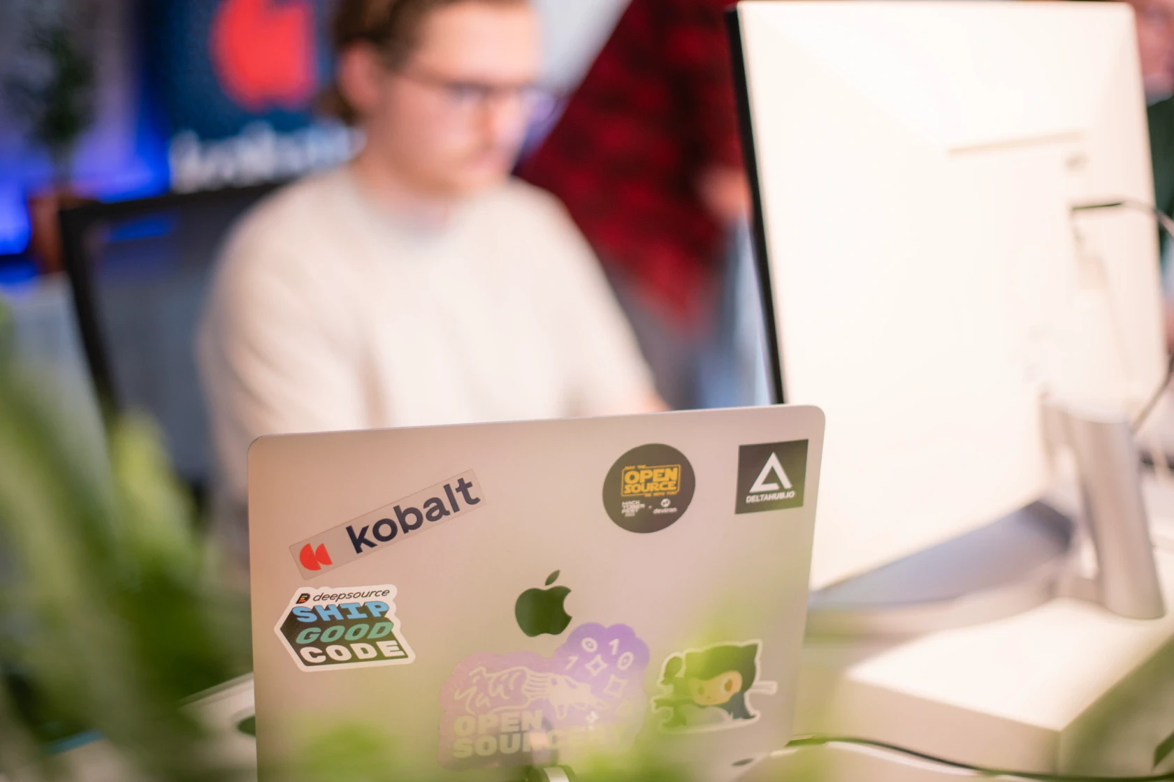 Kantoor laptop met stickers van open source projecten en het kobalt logo