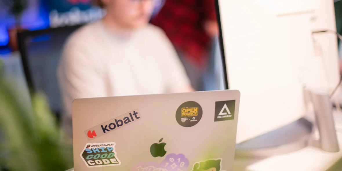 Kantoor laptop met stickers van open source projecten en het kobalt logo
