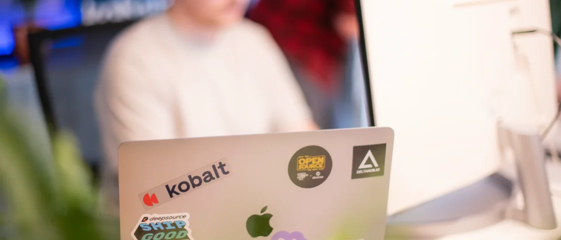 Kantoor laptop met stickers van open source projecten en het kobalt logo