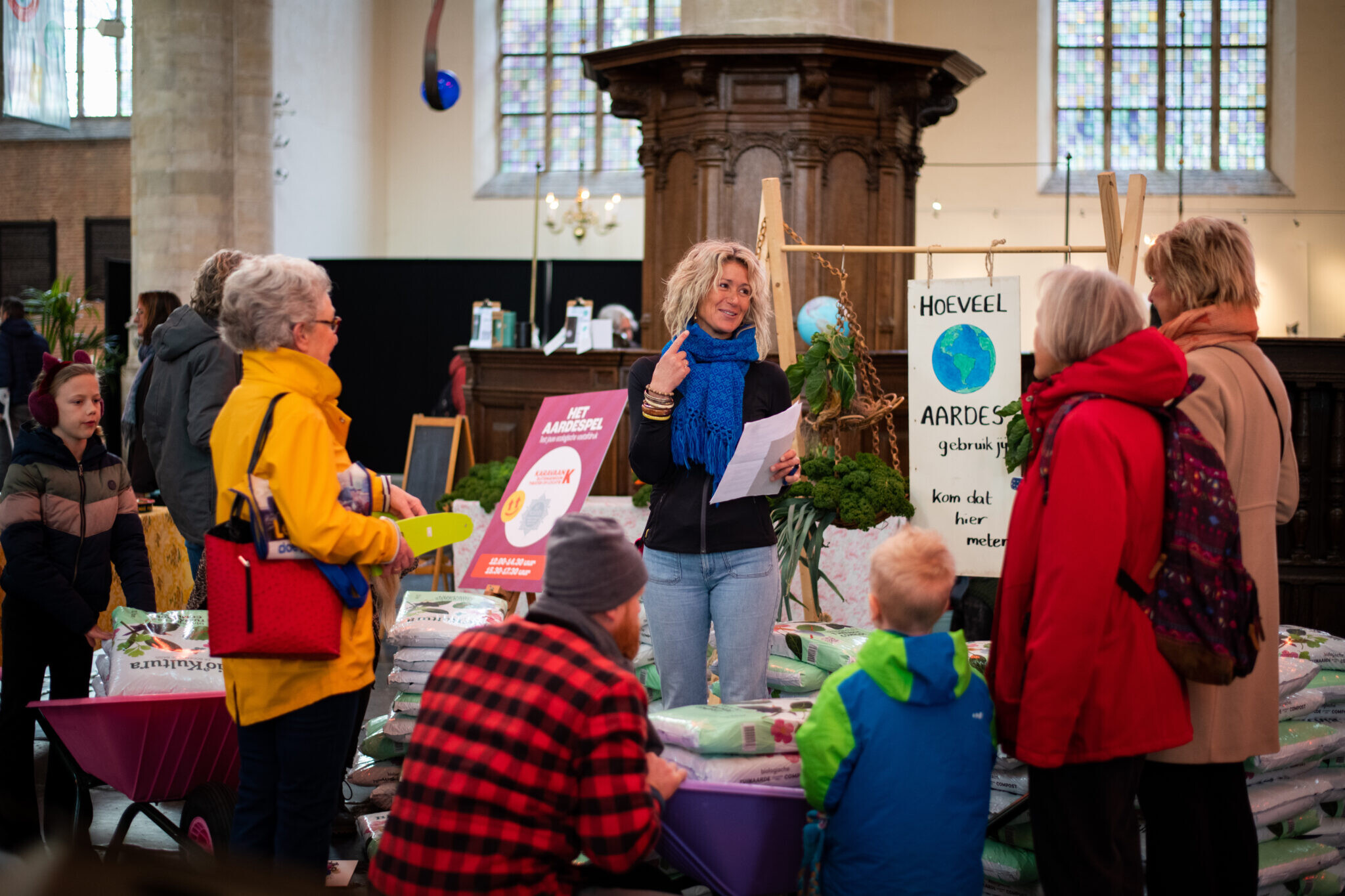 Vrouw bij een Upfest kraam met verschillende mensen eromheen.