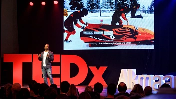 Man geeft een toespraak op een podium bij TEDxAlkmaar